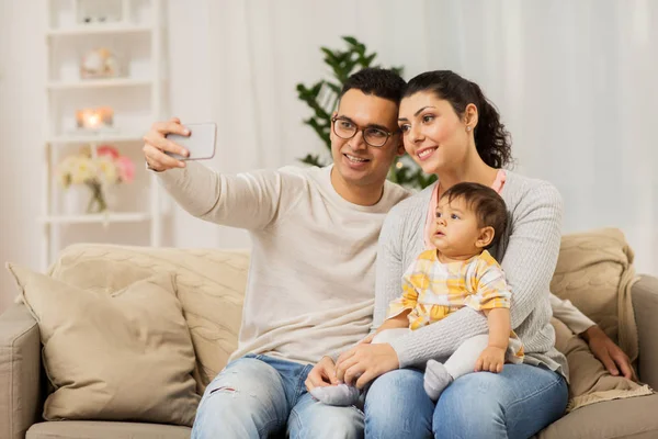 Mor och far med baby tar selfie hemma — Stockfoto