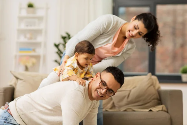 Família feliz e bebê filha jogando em casa — Fotografia de Stock