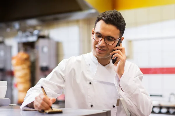 Chef en la tienda de kebab llamando en el teléfono inteligente —  Fotos de Stock