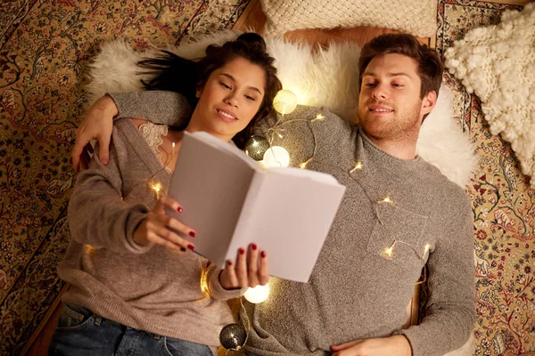 Feliz pareja leyendo libro en casa — Foto de Stock