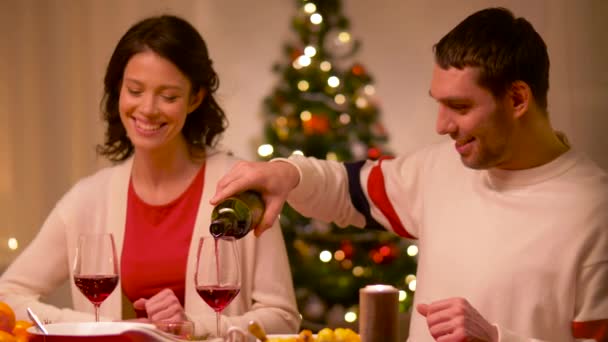 Feliz pareja bebiendo vino tinto en la cena de Navidad — Vídeo de stock