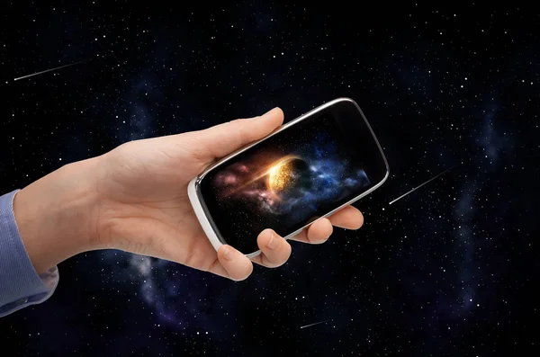 Mano con pianeta sullo schermo dello smartphone sullo spazio — Foto Stock