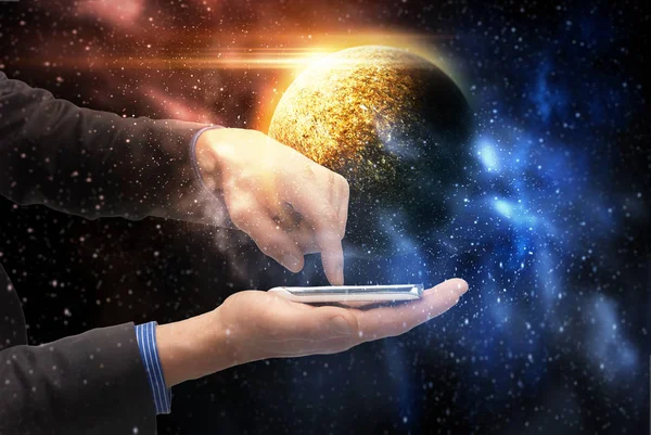 Mãos segurando smartphone sobre planeta no espaço — Fotografia de Stock