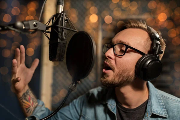 Homme avec écouteurs chantant au studio d'enregistrement — Photo