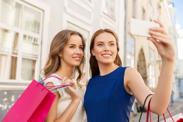 Женщины делают покупки и селфи на смартфоне — стоковое фото
