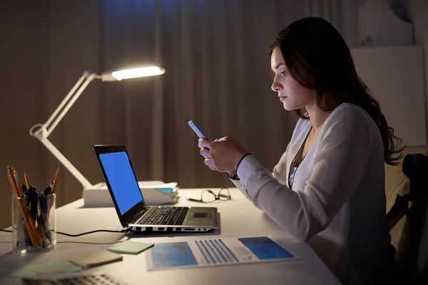 Businesswoman with smartphone and laptop at office — Stock Photo, Image