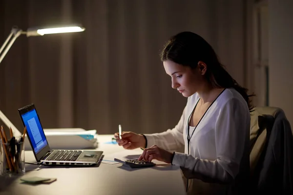 Woman with calculator and papers at night office — Stock Photo, Image