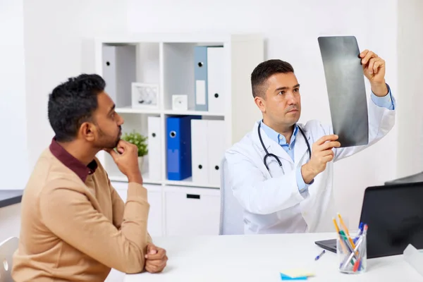 Лікар з рентгенівським і чоловічим пацієнтом у клініці — стокове фото