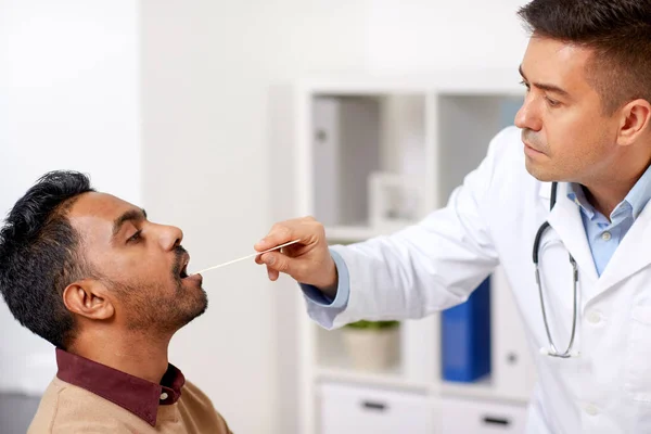 Médico examinando paciente garganta na clínica — Fotografia de Stock