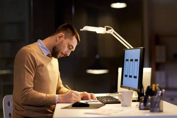 Om cu notepad de lucru la birou de noapte — Fotografie, imagine de stoc