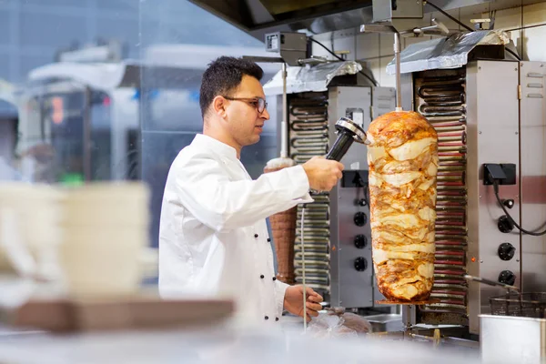 Chef tranchant la viande doner de la broche au kebab shop — Photo