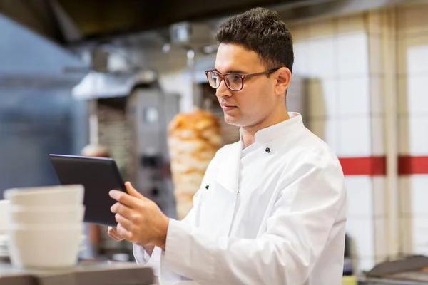 Kucharz z komputera typu tablet w restauracji kitchen — Zdjęcie stockowe