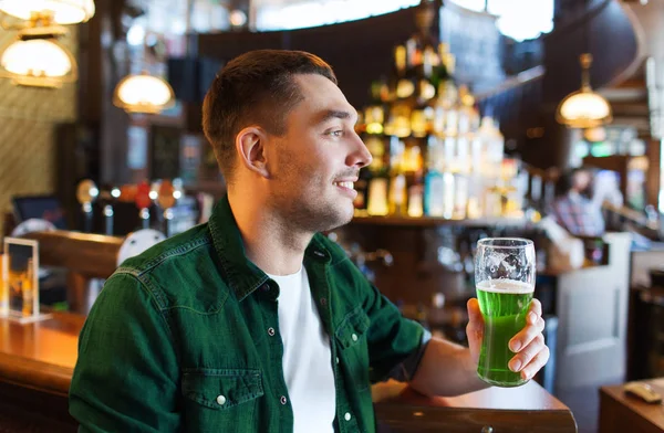 Mannen dricker gröna öl på bar eller pub — Stockfoto