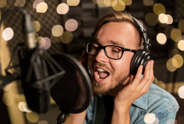 Man met hoofdtelefoon zingen bij opnamestudio — Stockfoto