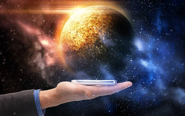 Hand som håller smartphone över planet i rymden — Stockfoto