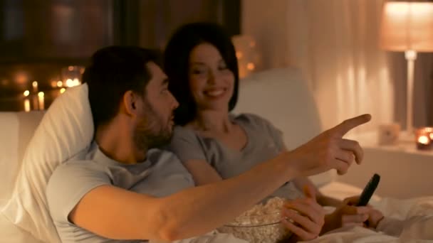 Пара з попкорном дивиться телевізор вдома — стокове відео