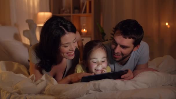 Familia feliz con la tableta PC en la cama en casa — Vídeos de Stock