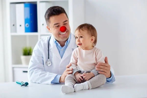stock image happy baby girl at doctor on red nose day