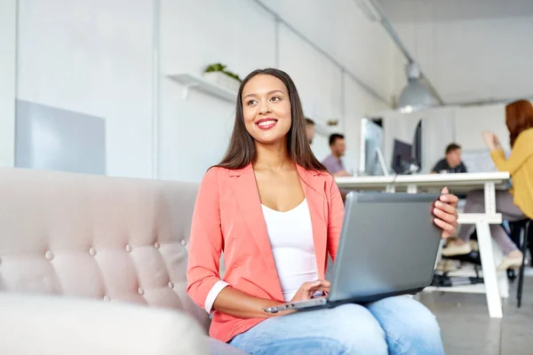 Mujer feliz con el ordenador portátil trabajando en la oficina — Foto de Stock