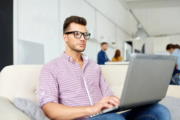 Uomo in occhiali con computer portatile che lavora in ufficio — Foto Stock