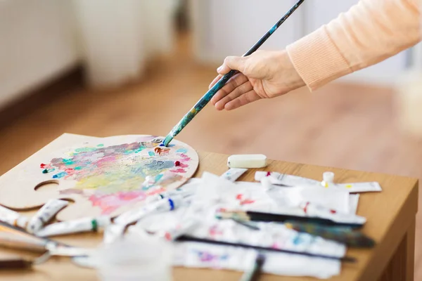 Mão artista com pincel e paleta de cores — Fotografia de Stock