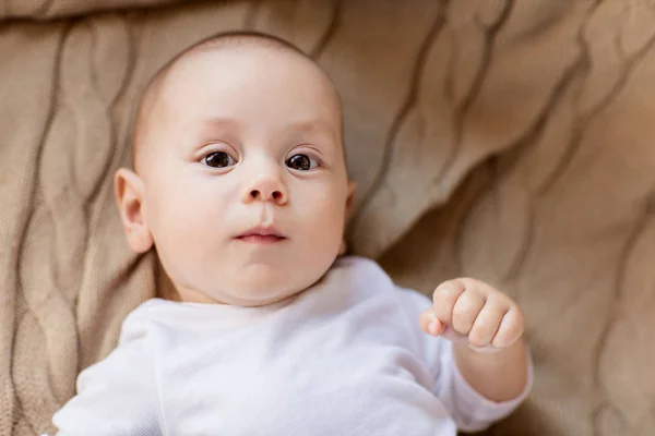 Süßer kleiner Junge liegt auf Strickdecke — Stockfoto