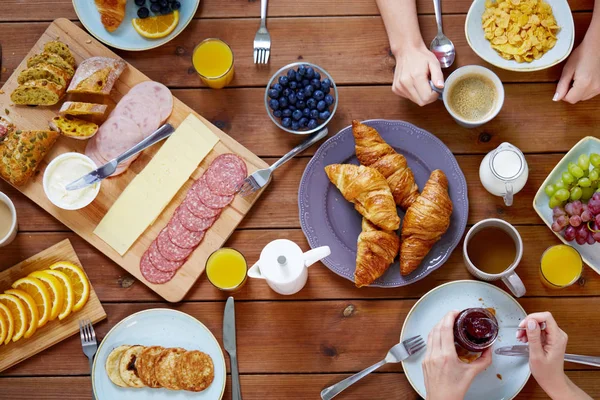 テーブルで朝食を持つ人々 のグループ — ストック写真