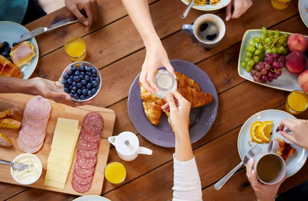 Pessoas tomando café da manhã à mesa com alimentos — Fotografia de Stock
