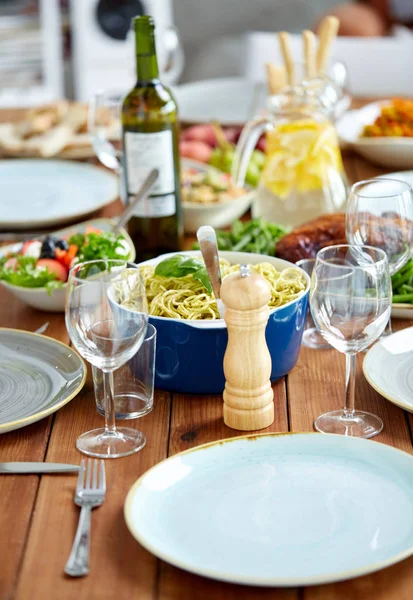 Moinho de pimenta ou moedor de sal na mesa com alimentos — Fotografia de Stock