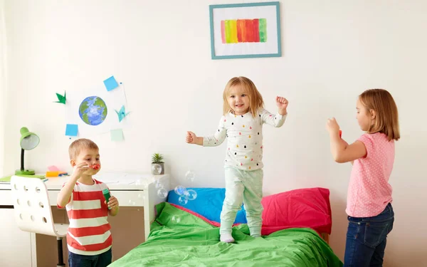 Kids blowing soap bubbles and playing at home — Stock Photo, Image