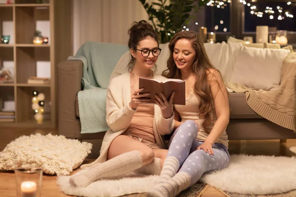 Felices amigas leyendo libro en casa — Foto de Stock