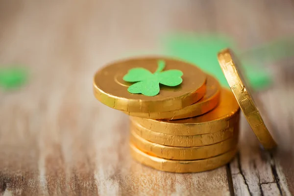 Monedas de oro con trébol sobre mesa de madera —  Fotos de Stock