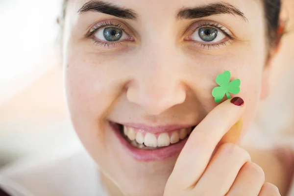 Mutlu genç kadın yüz shamrock ile yakın çekim — Stok fotoğraf