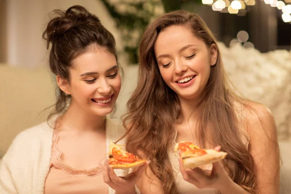 Щасливі друзі-жінки їдять піцу вдома Стокове Фото