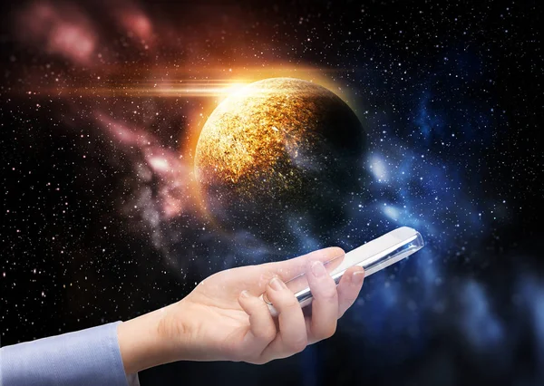 Ruka držící smartphone nad planetou ve vesmíru — Stock fotografie