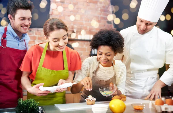 Happy friends en chef kok bakken in de keuken — Stockfoto