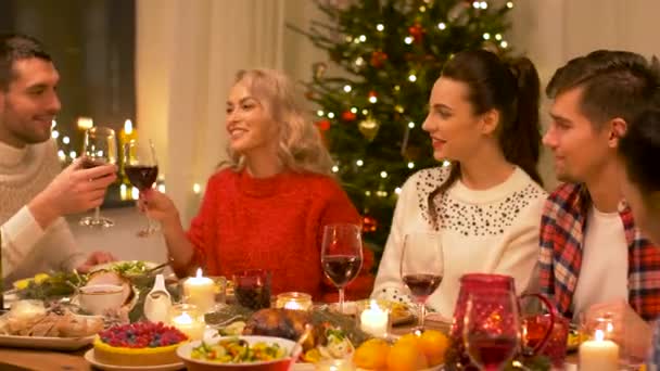 Ευτυχείς φίλοι πόσιμο κόκκινο κρασί, Χριστούγεννα — Αρχείο Βίντεο