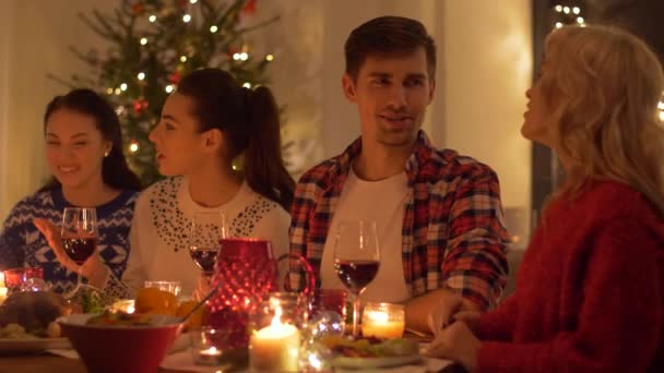 Amigos felices teniendo la cena de Navidad en casa — Vídeo de stock