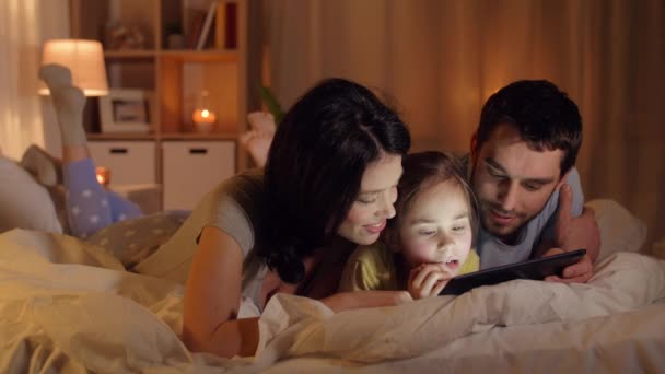 Família feliz com tablet pc na cama em casa — Vídeo de Stock