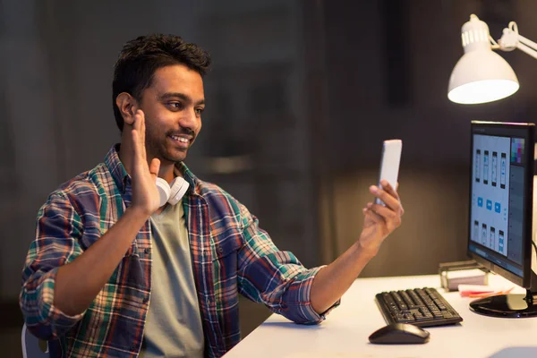 Hombre con smartphone que tiene videollamada en la oficina —  Fotos de Stock