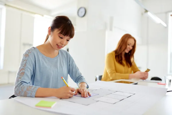 Female architect with blueprint working at office — Stock Photo, Image