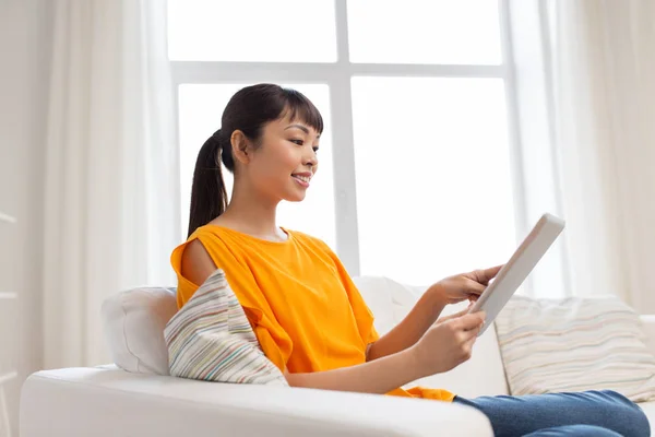 Happy young asian woman with tablet pc at home — Stock Photo, Image