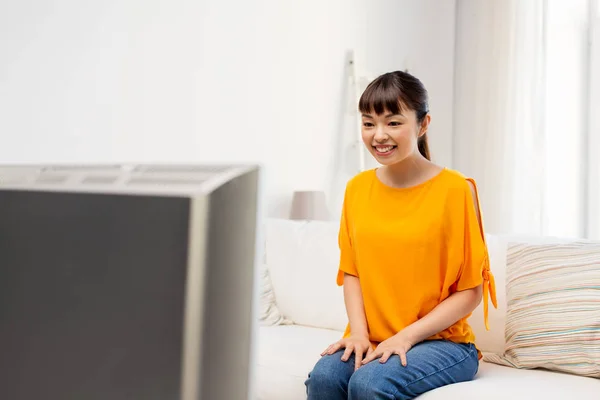 Felice donna asiatica con guardare la tv a casa — Foto Stock