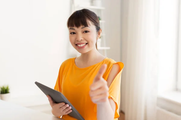 Student with tablet pc showing thumbs up at home — Stock Photo, Image