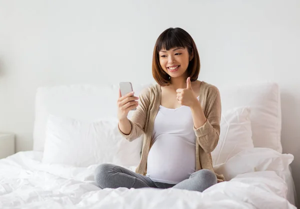 Mulher grávida tomando selfie por smartphone em casa — Fotografia de Stock