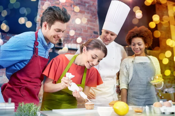 Amigos felizes e cozinheiro chef assar na cozinha — Fotografia de Stock