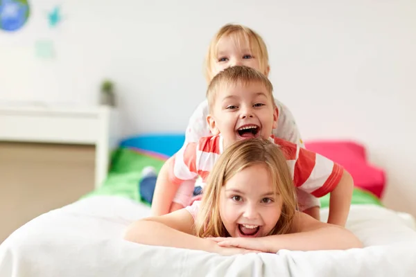 Щасливі маленькі діти розважаються в ліжку вдома — стокове фото