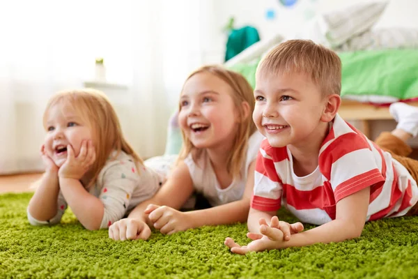 Bambini felici sdraiati sul pavimento o sul tappeto — Foto Stock