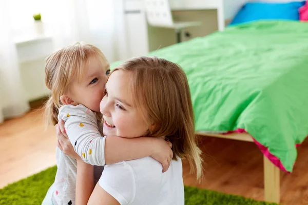 Niñas o hermanas felices abrazándose en casa — Foto de Stock