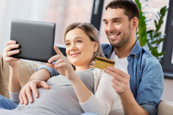 Mężczyzna i żona w ciąży, zakupy online w domu — Zdjęcie stockowe